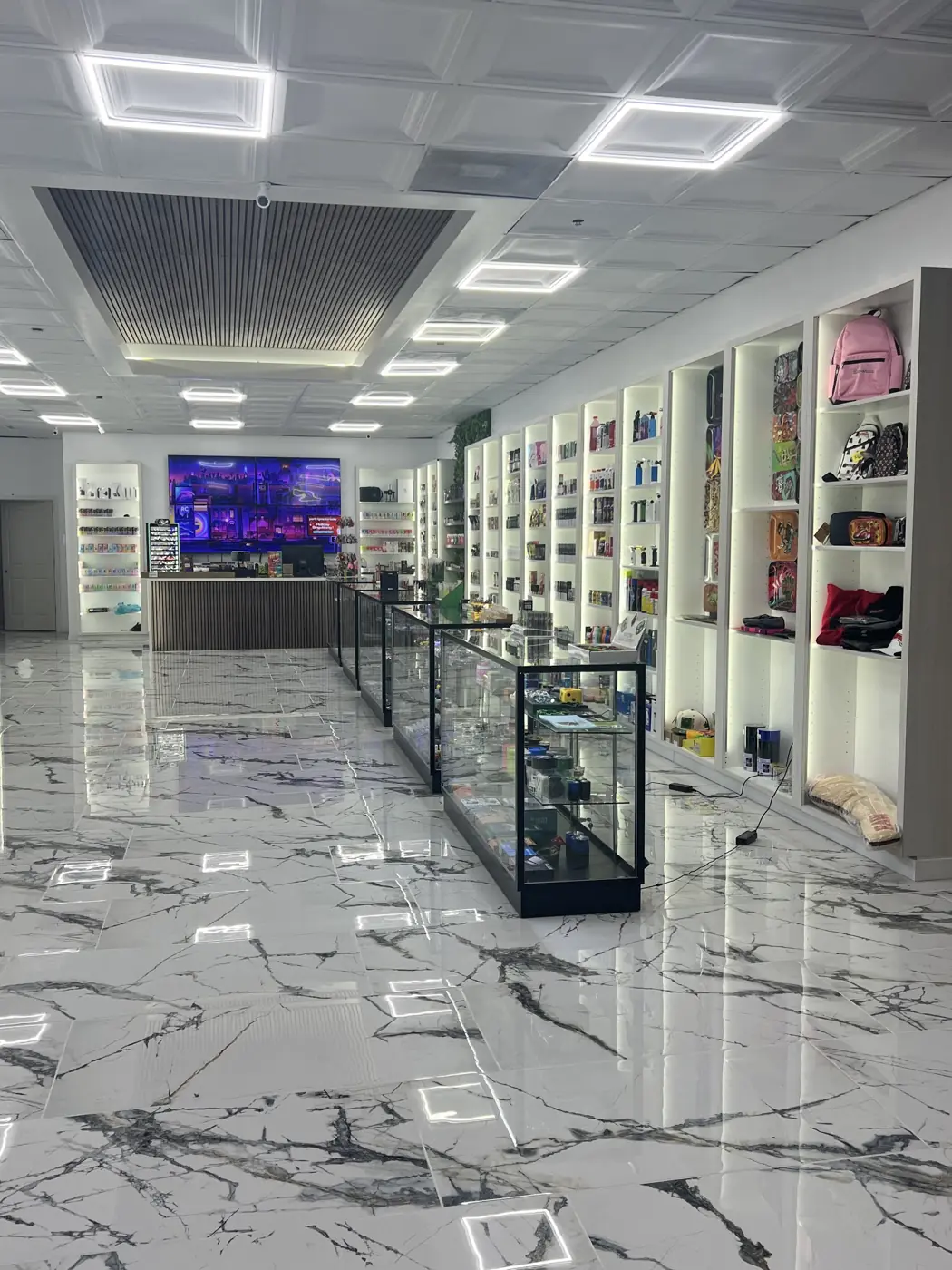 Marble floor, open shelves, and glass cases inside Huff N Puff Atascocita